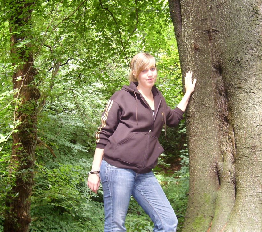 Malina als junge Frau im Wald, an einem Baum lehnend